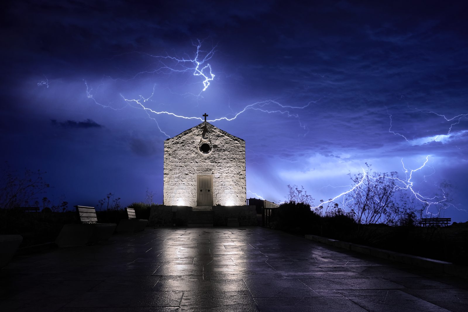 Lightning crawlers spreading above the floodlit chapel at Dingli, Malta